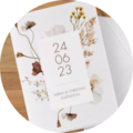 Elegant invitation card with botanical design and date.
