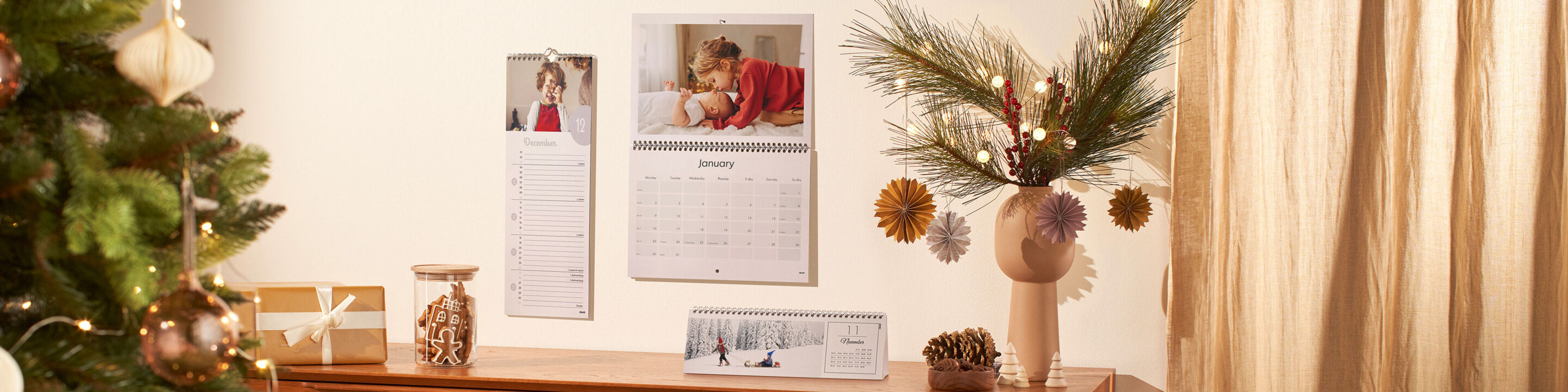 A cozy living area with a decorated Christmas tree and two wall calendars.