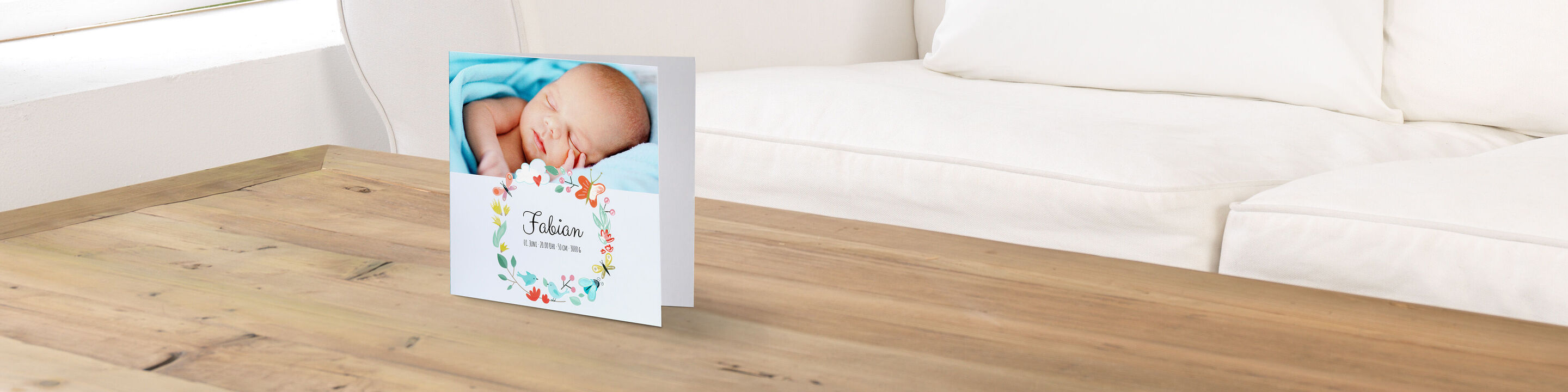 A lovely greeting card with a sleeping baby. The card shows a colorful flower wreath and the name 'Tobias.'