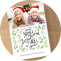 A cheerful family photo with two children in Christmas hats posing on a Christmas-decorated card. The text on the card reads: "It's the Most Wonderful Time of the Year!"